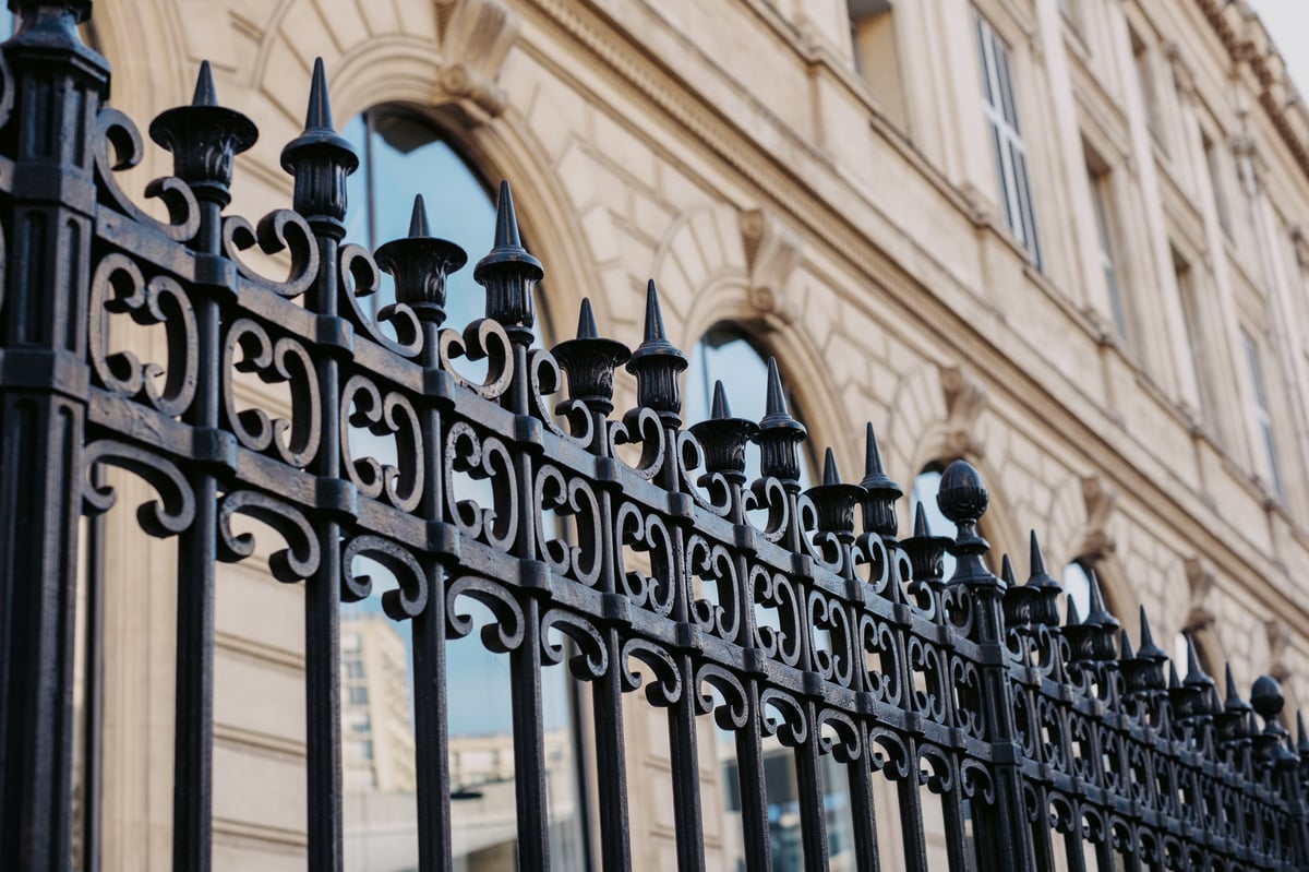Ornate iron fence in front of historic brick building